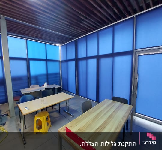 וילונות כחולים מכסים חלונות בחדר ישיבות